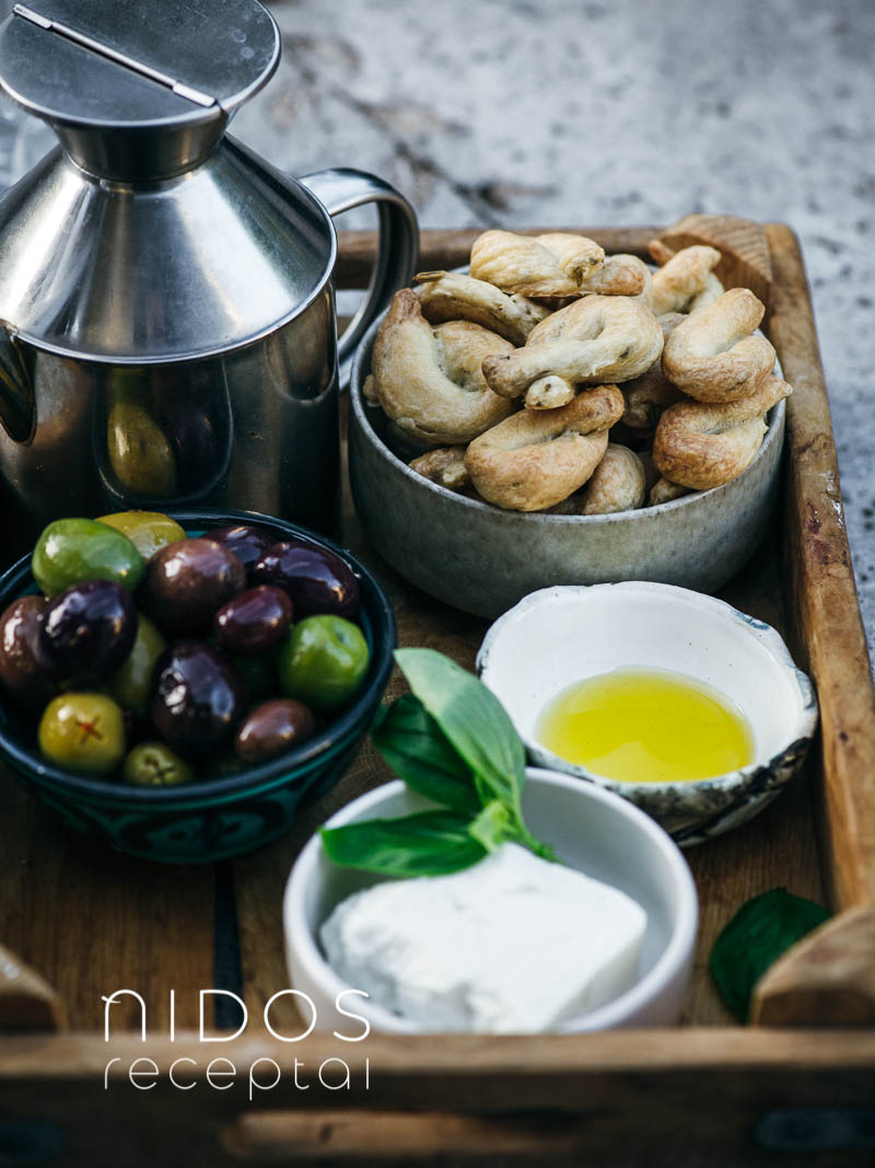 Taralli Italian crispy cookies on a board with olives and oil